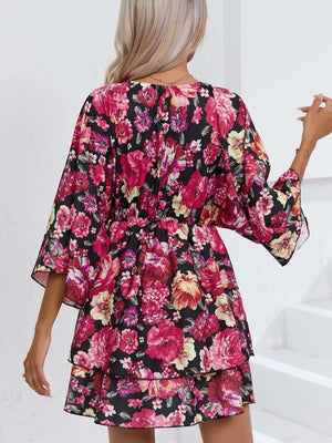 Black floral ruffle hem mini dress with tiered skirt and bell sleeves.