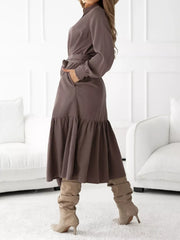 Coffee brown midi dress with ruffle hem, tie waist, and ruffled cuffs.