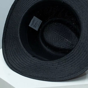 Black straw boater sun hat interior view with woven texture and care label.