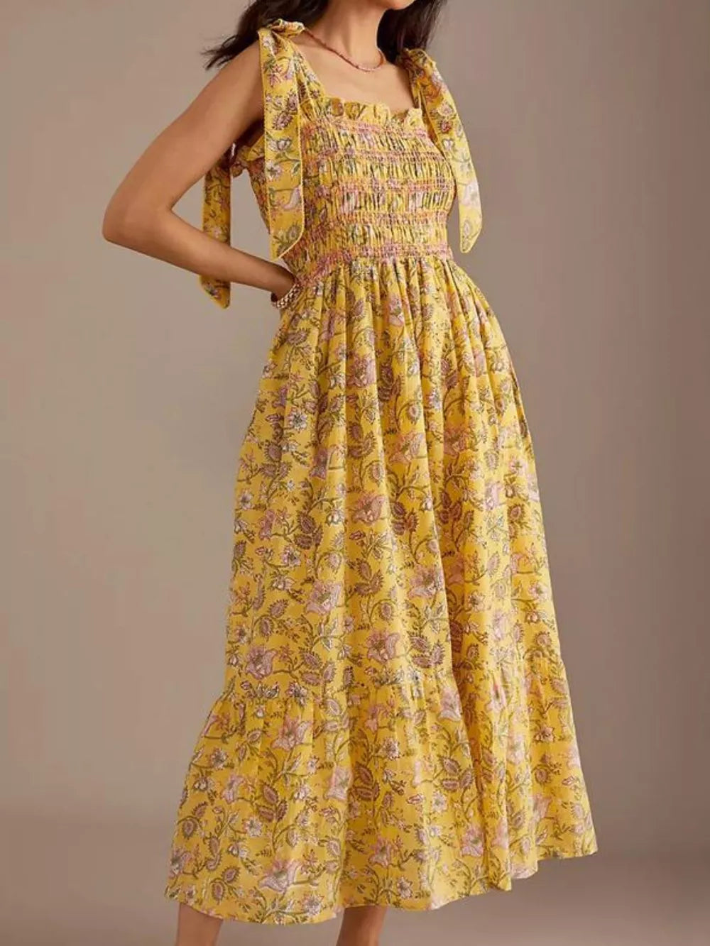 Yellow floral midi dress with tie shoulders and smocked bodice.