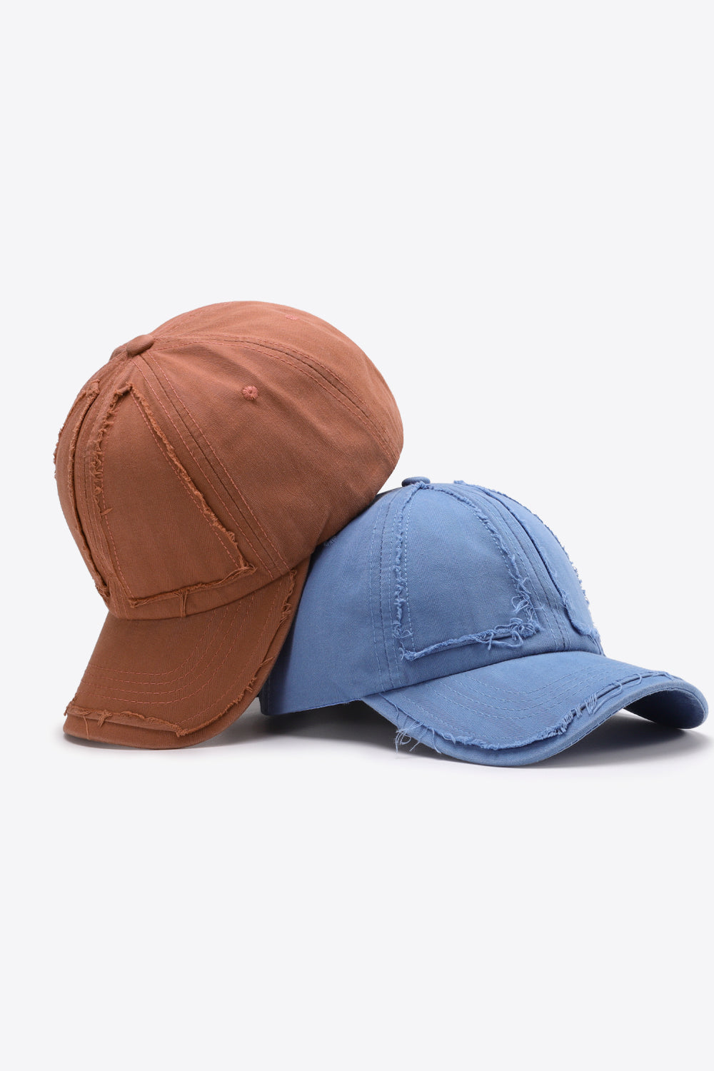 Raw edge denim baseball caps in Camel and Cobalt Blue with distressed details.