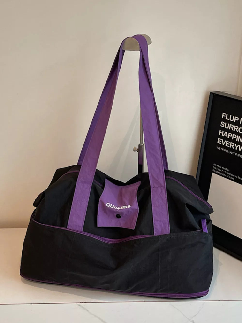 Premium two-tone nylon travel bag in black with purple accents.