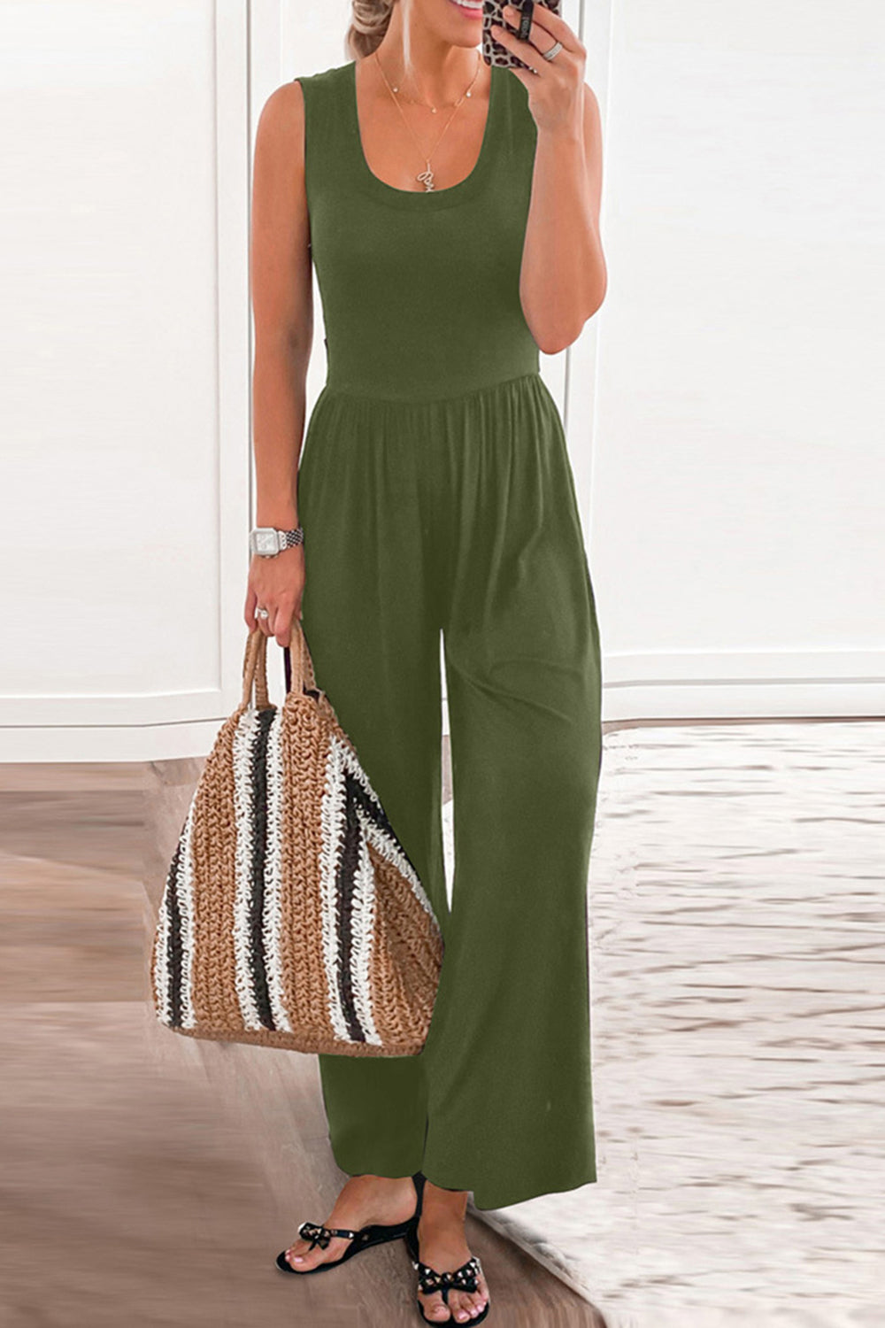 Moss green gathered waist wide leg jumpsuit with scoop neck and sleeveless design.