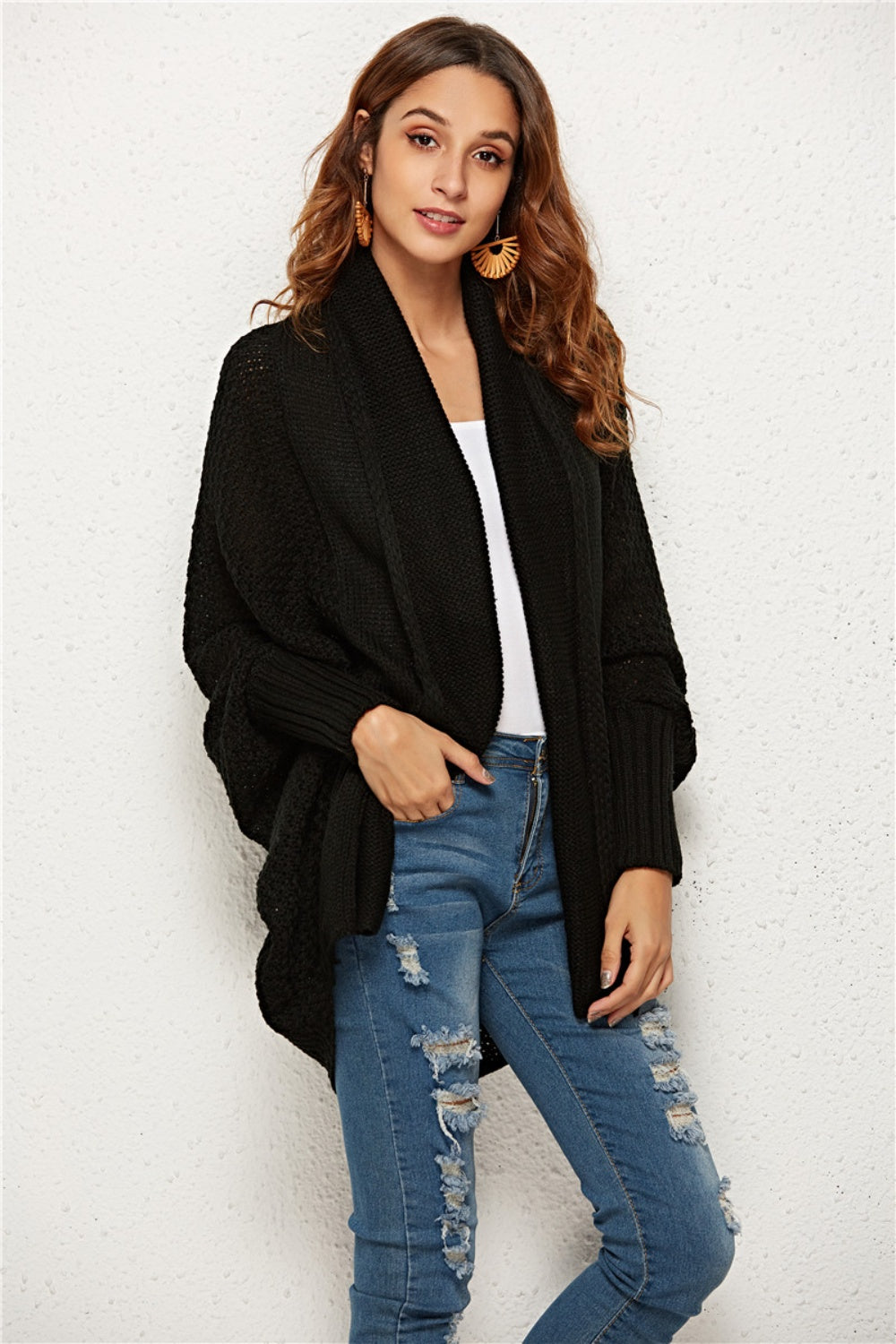 Black textured cocoon knit cardigan with batwing sleeves and shawl collar.