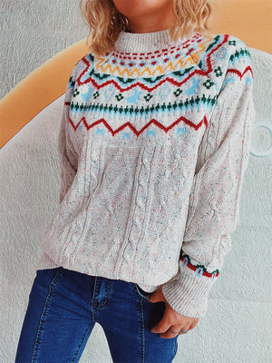 Beige cable knit turtleneck sweater with Fair Isle yoke and speckled yarn.