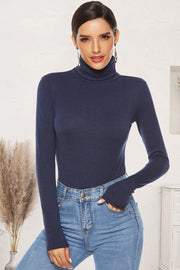 Dark blue ribbed turtleneck bodysuit with long sleeves, styled with jeans.