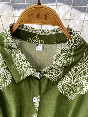 Green button-down romper with white paisley print, collared neckline.