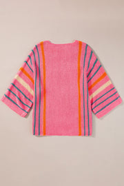 Colorblock sleeve knit pullover in pink with vertical orange and teal stripes and horizontal stripes on sleeves.