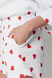 White gauze pajama shorts with red heart print and a pocket detail.
