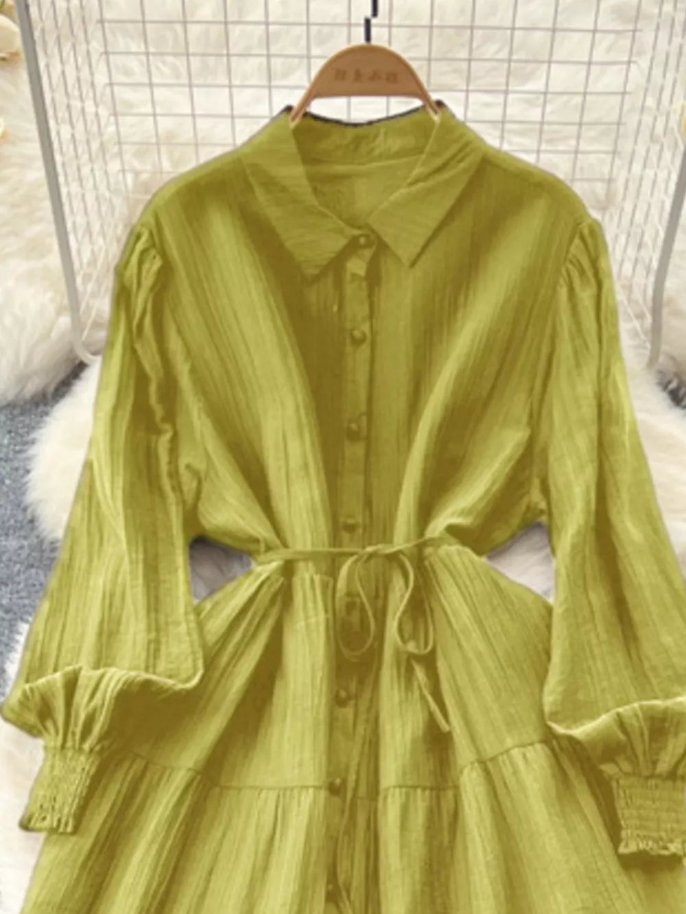 Yellow-green textured tiered long sleeve button-down dress with cinched waist and smocked cuffs.