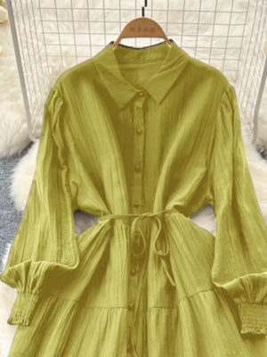 Yellow-green textured tiered long sleeve button-down dress with cinched waist and smocked cuffs.
