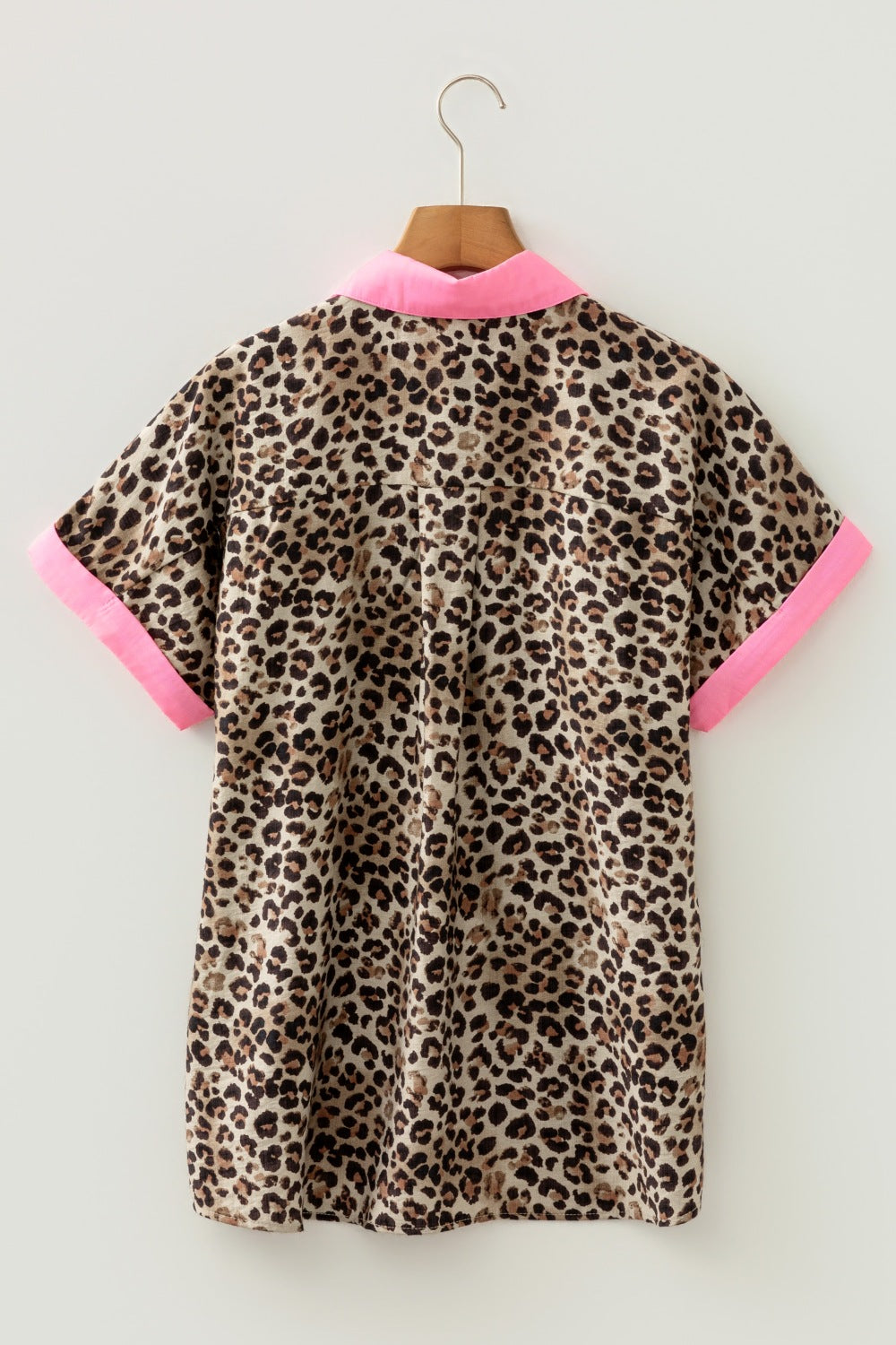 Short sleeve button up shirt with leopard print and neon pink collar and cuffs.