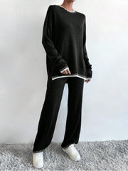 Black acrylic knit loungewear set with white contrast stitching on neckline, cuffs, and hem.