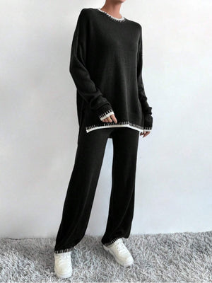 Black acrylic knit loungewear set with white contrast stitching on neckline, cuffs, and hem.