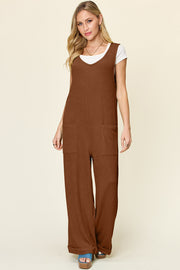 Caramel ribbed knit jumpsuit with tie straps, V-neck, and front pockets.