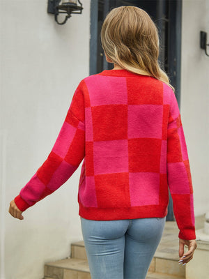 Checkerboard block knit cardigan in red and pink with crew neck and long sleeves.