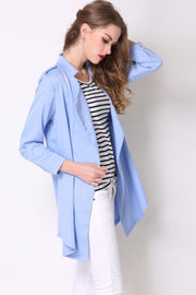Light blue drape-front trench coat with shoulder detailing and buttoned cuffs.
