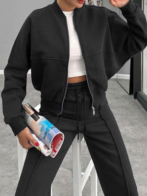 Black bomber jacket with zip front and wide-leg track pants with drawstring waist.
