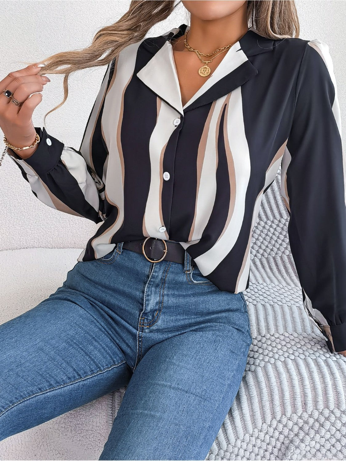 Wavy stripe collared blouse with button front and long sleeves, styled with jeans.
