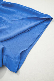 Blue textured drawstring shorts showing hem detail and relaxed fit.