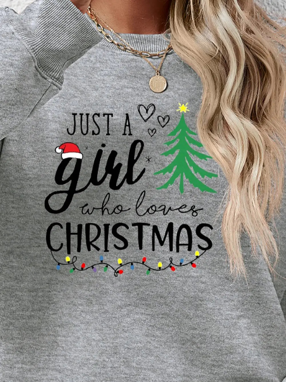 Grey crewneck sweatshirt with "Just a girl who loves Christmas" graphic and Christmas lights.