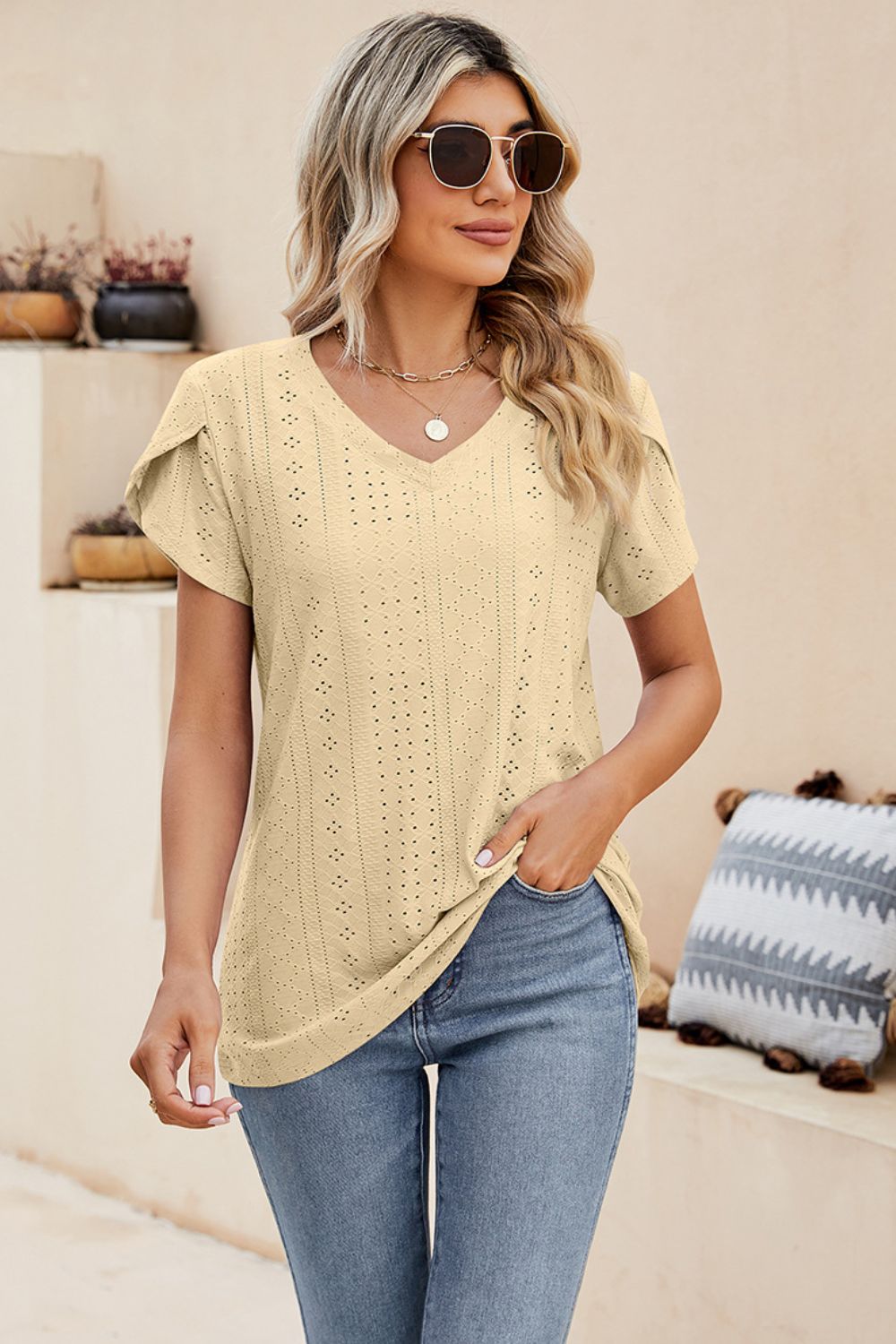 Light yellow knit top with perforated sleeve detail and v-neck