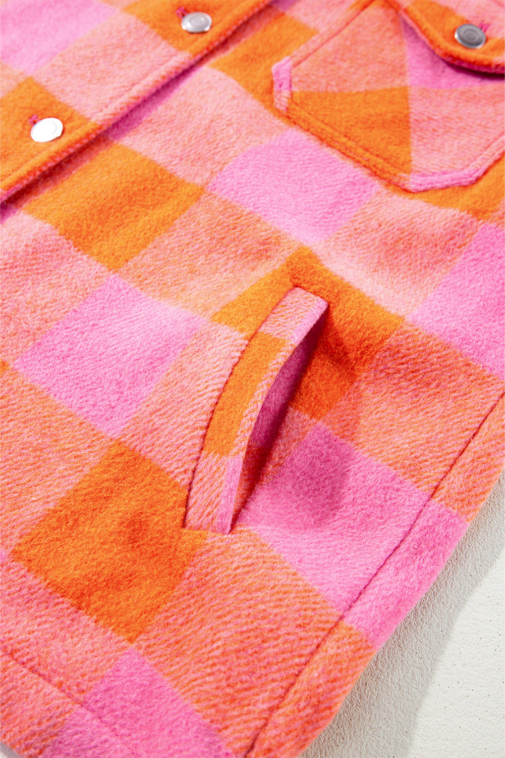 Overshirt with orange and pink plaid pattern, featuring patch pockets and snap buttons.
