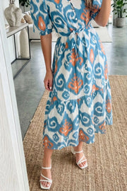 Ikat floral midi dress with puff sleeves, tie waist, and tiered skirt in blue, orange, and white cotton.