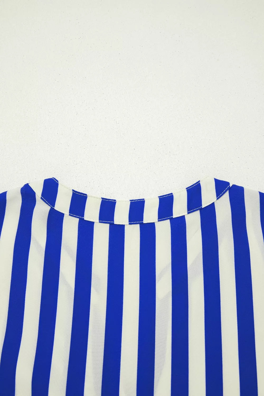 Blue and white striped button-down shirt with balloon sleeves and a collared neckline.