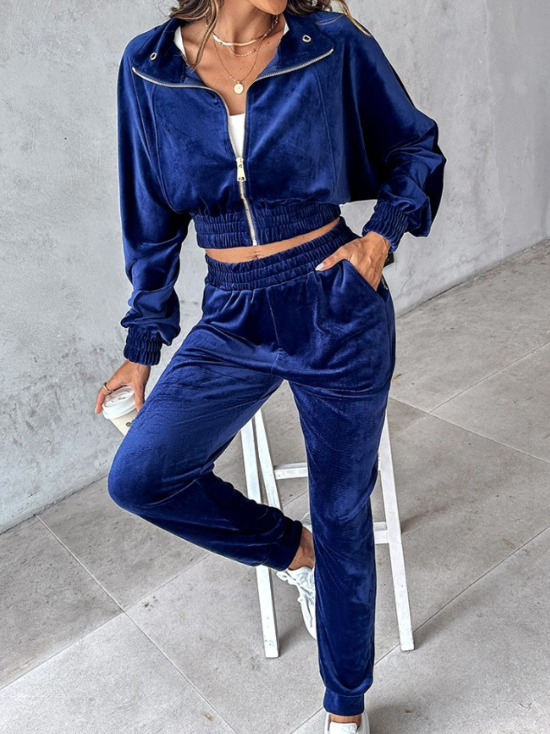 Navy velvet crop tracksuit with zipper detail and elastic waistband.