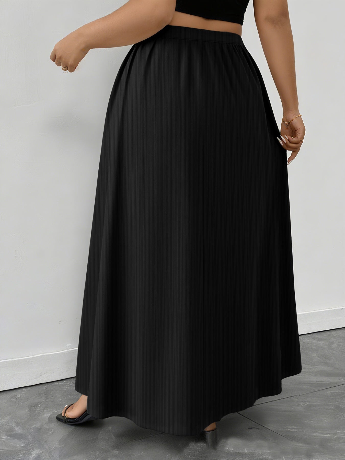 Black ribbed maxi skirt with a-line cut and pockets, shown on a model.