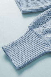 Light blue knit cardigan with diamond-cut sleeve detail and ribbed cuffs.