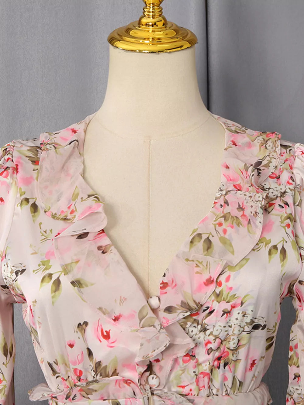 Charming ruffled floral mini dress with button front and V-neckline.