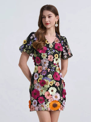 Black floral mini dress with puff sleeves and colorful applique flowers.