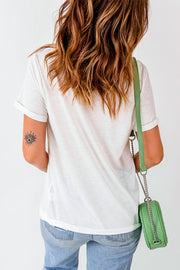 White graphic t-shirt with rolled sleeves and a casual fit, styled with jeans and a green crossbody bag.