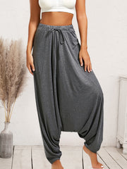 Charcoal drape-front harem pants with drawstring waist and wide legs.