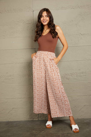 Polka dot wide leg culottes in dusty pink with a brown polka dot pattern.
