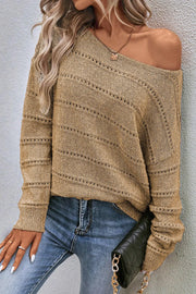 Tan off-the-shoulder knit pullover sweater with openwork detail and boat neckline.