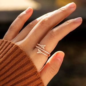 Gold bypass ring with two diamond-accented butterfly charms.