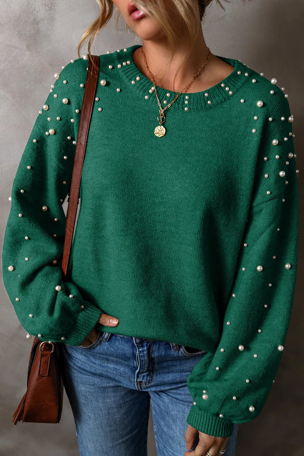 Dark green knit sweater with pearl embellishments on sleeves and neckline.