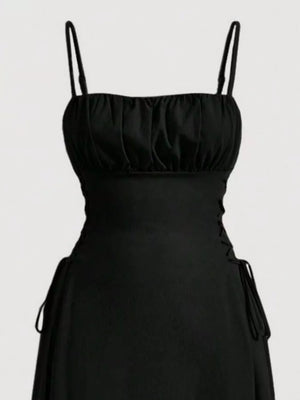 Black cami dress with ruched bodice and crisscross lace-up sides.