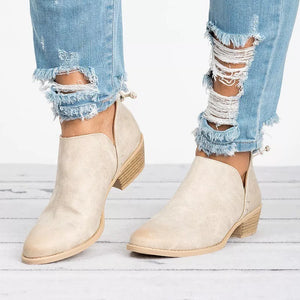 Beige V-cut pointed toe block heel boots with side cutouts styled with distressed jeans.