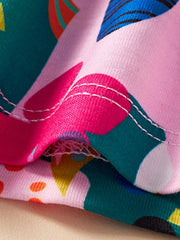 Toddler dress with playful jungle print, pink fabric, and white stitching detail.