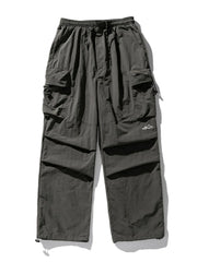 Oversized dark gray utility cargo pants with multiple pockets and drawstring waist.