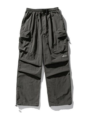 Oversized dark gray utility cargo pants with multiple pockets and drawstring waist.