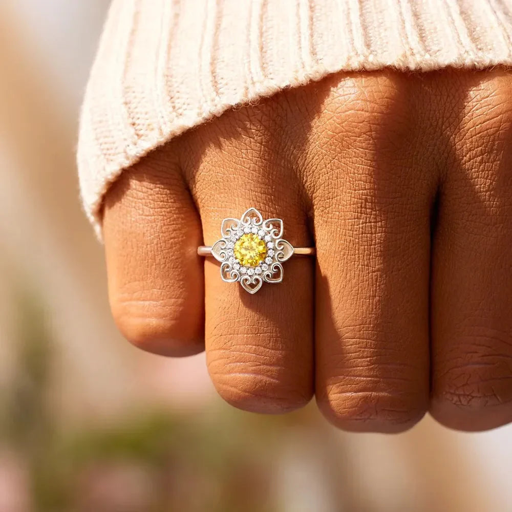 Silver floral filigree ring with yellow center stone and clear accent stones