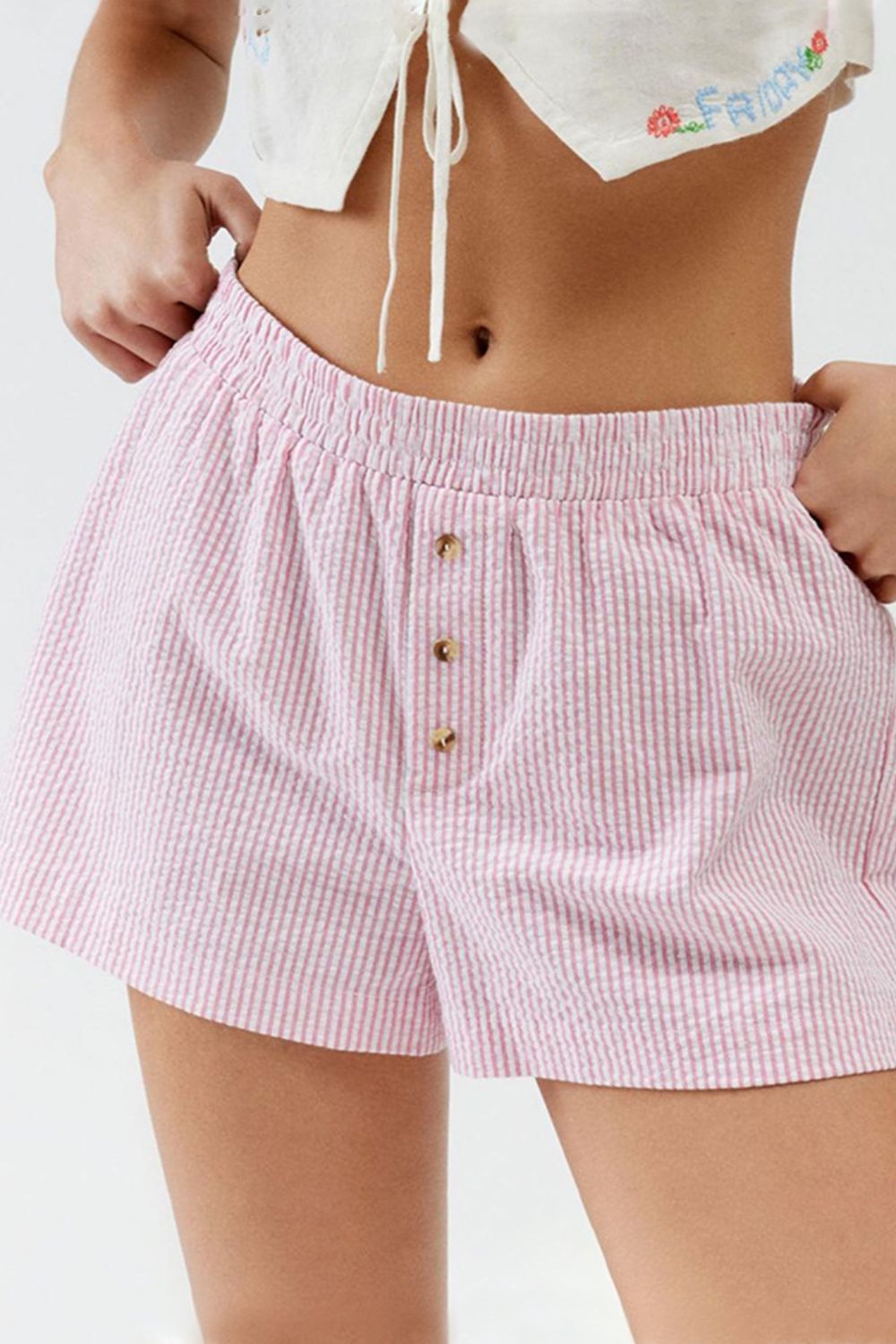 Pink and white seersucker boxer shorts with button fly and elastic waist.