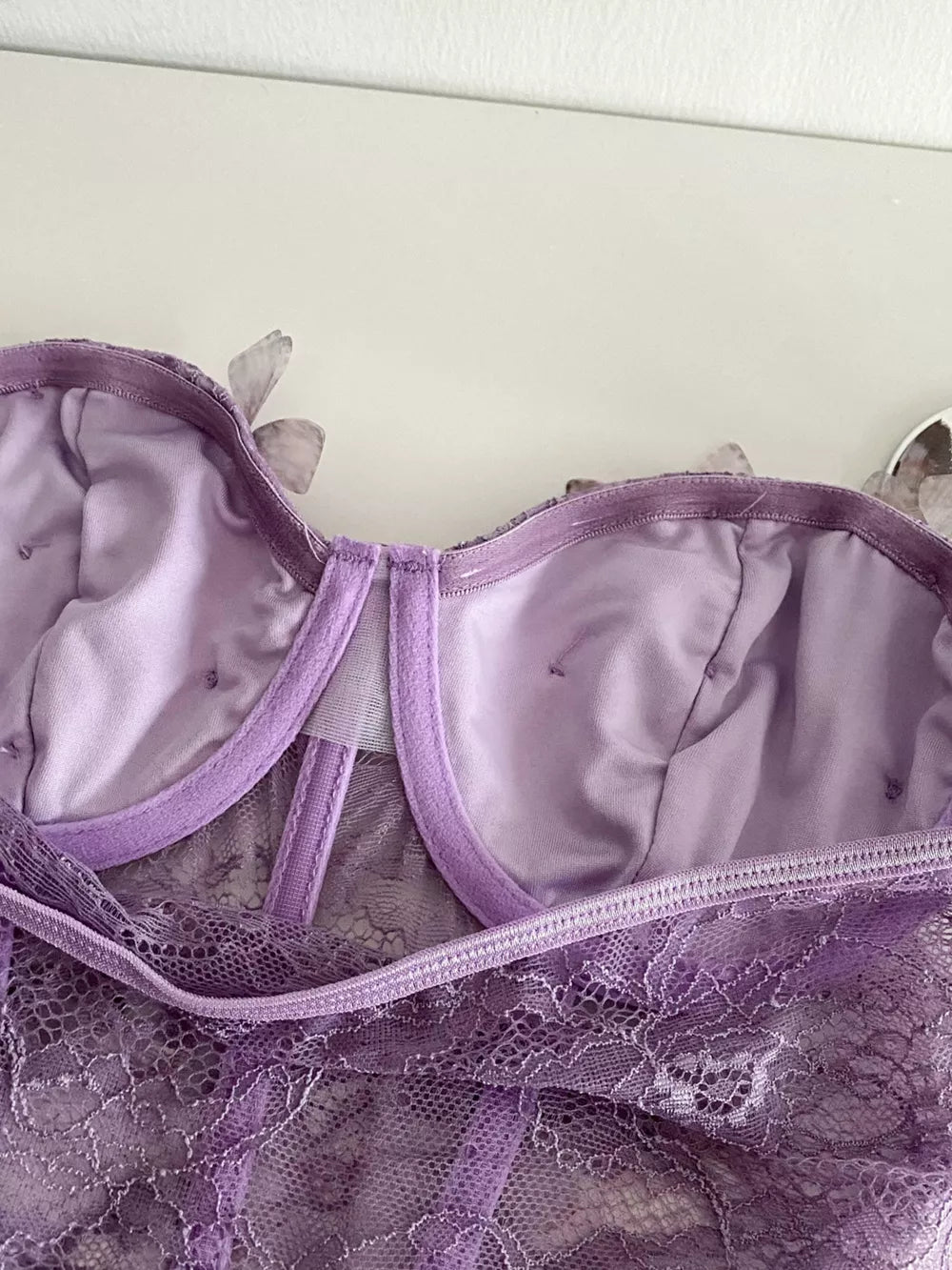 Purple lace bustier top with butterfly appliques and bow detail.