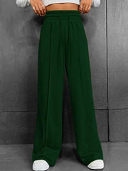 Dark green relaxed wide-leg sweatpants with drawstring waist and side seams.