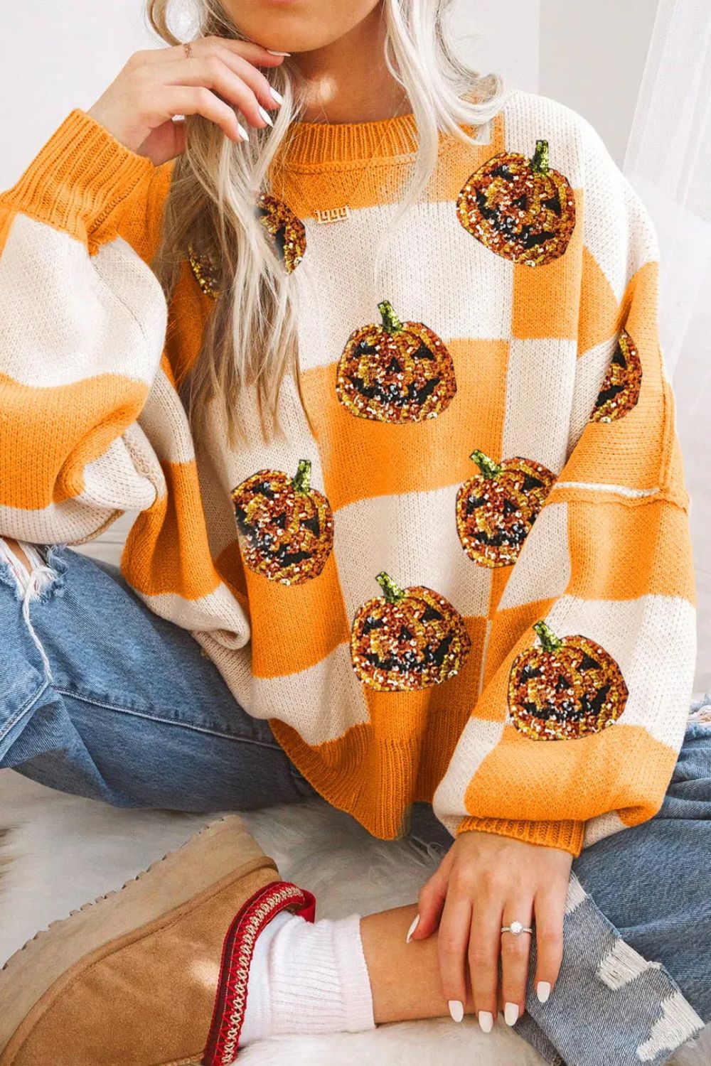 Checkerboard pumpkin appliqué knit sweater in tangerine and cream with sequin detail.